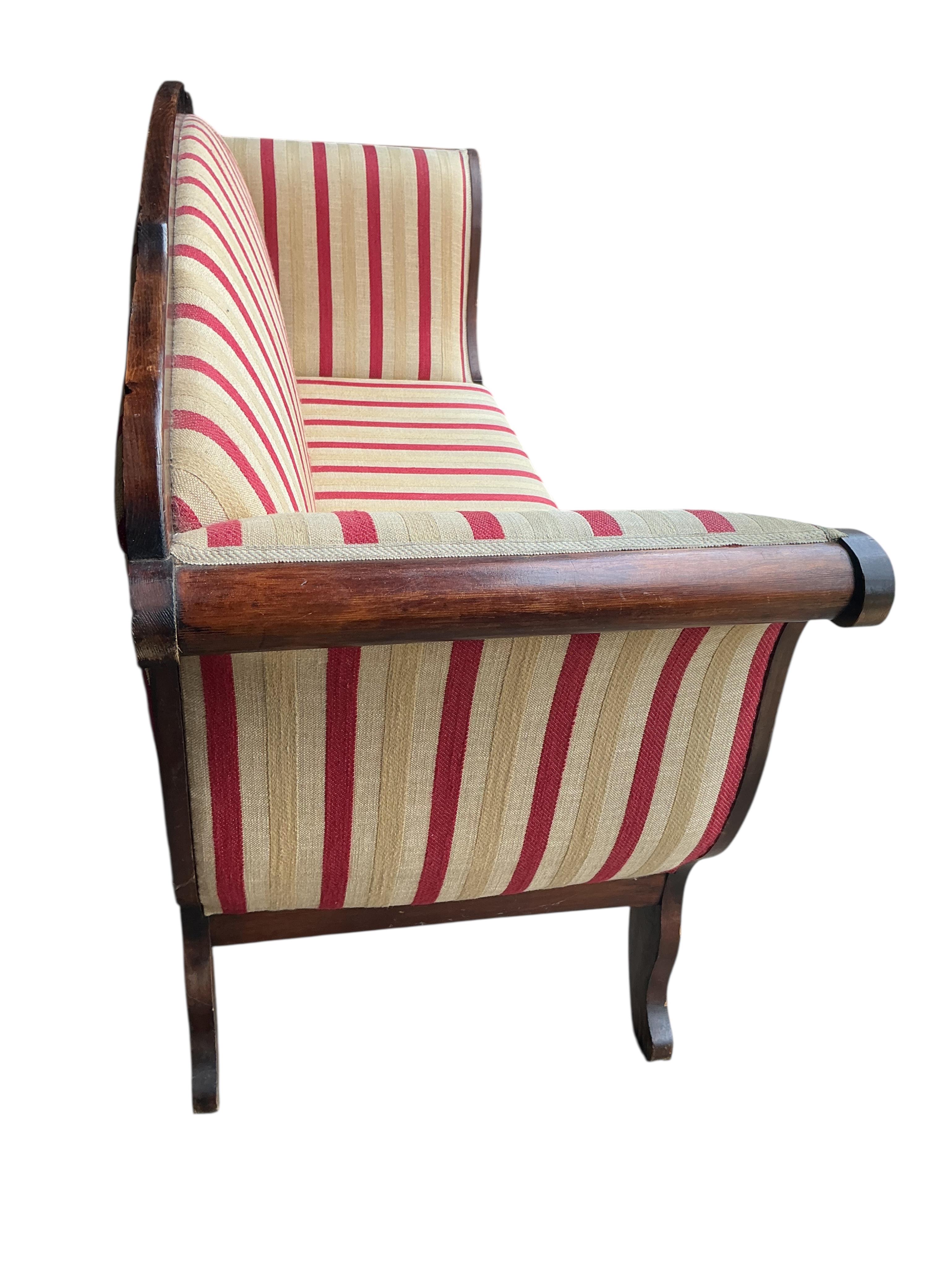 An early 19th century Continental pine scroll arm settee, width 190cm, depth 62cm, height 103cm